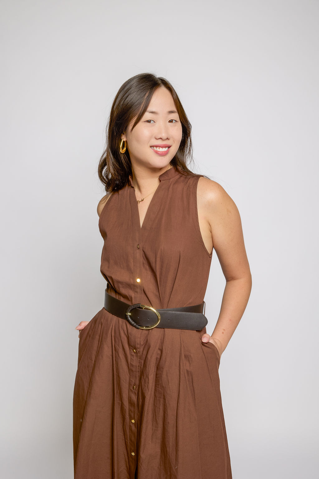 Studio fashion portrait in a brown belted dress