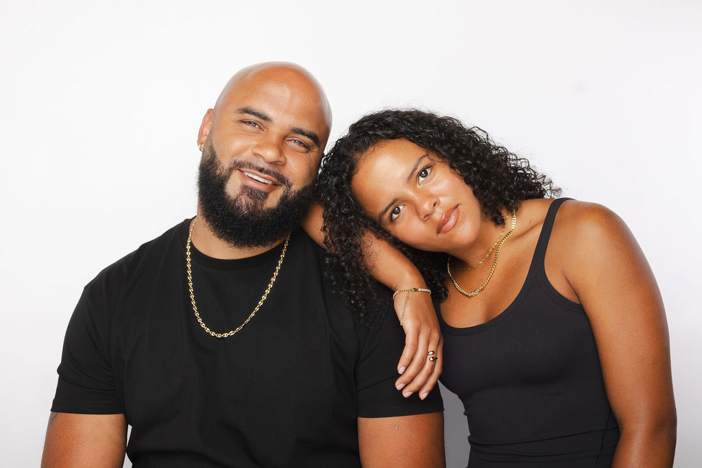 Studio portrait of a couple in black, her head on his shoulder