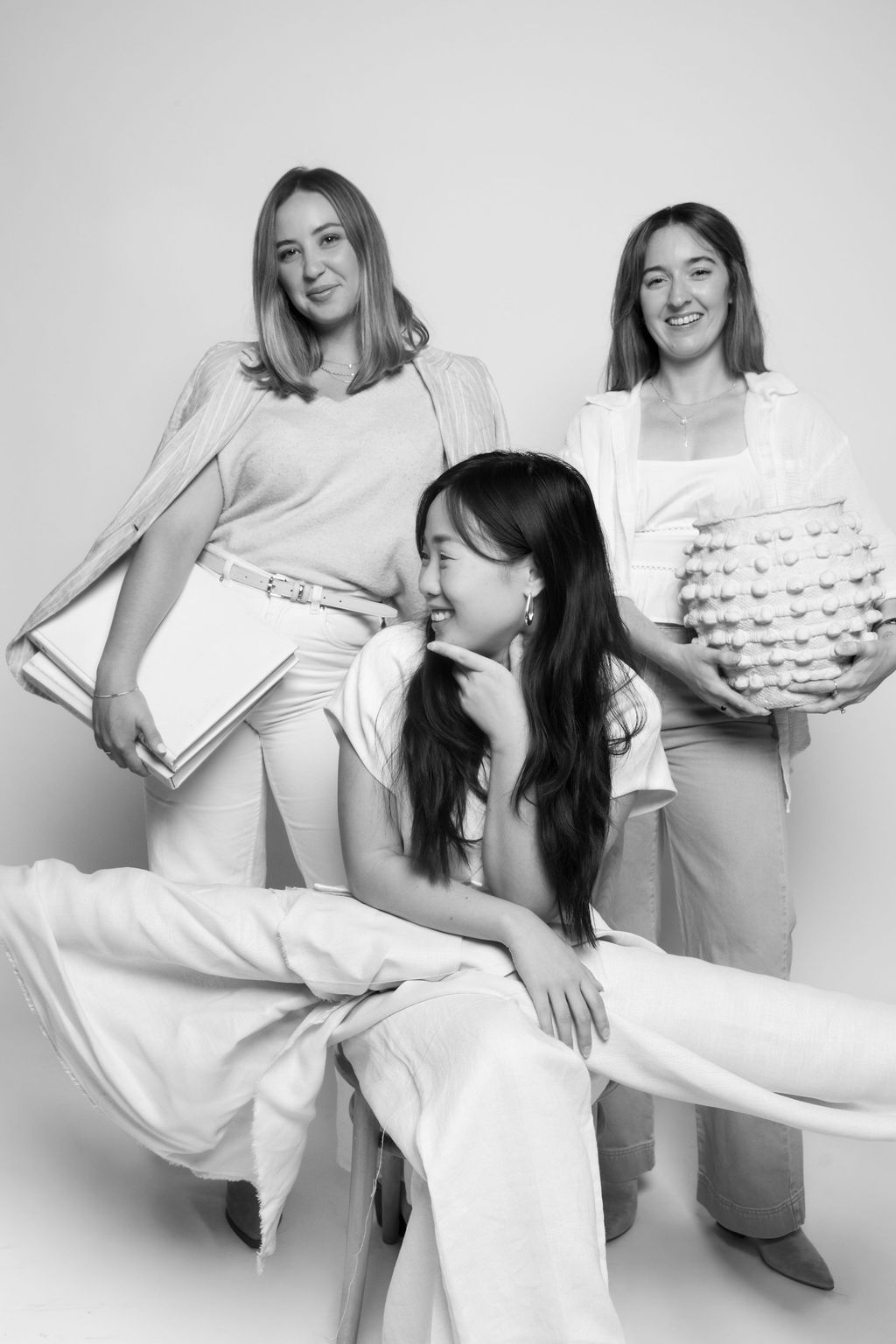 Black-and-white studio portrait of a creative trio