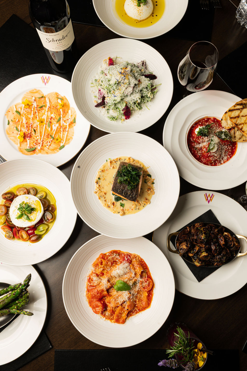 Overhead dinner spread with salmon, pasta, and brussels sprouts